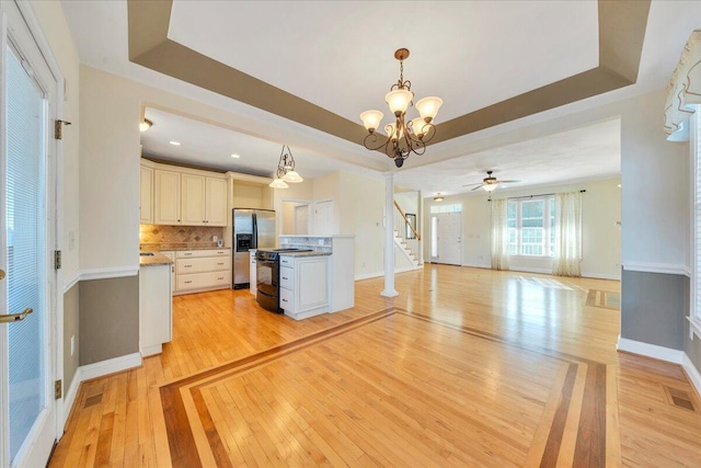 kitchen with a raised ceiling, stainless steel refrigerator with ice dispenser, and black / electric stove