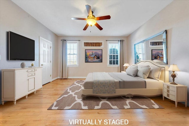 bedroom featuring ceiling fan, light wood-type flooring, and baseboards