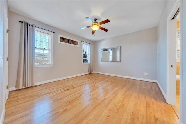unfurnished room with ceiling fan, light wood-style flooring, and baseboards