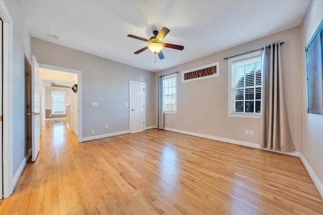 empty room with light wood-style flooring, baseboards, and a ceiling fan