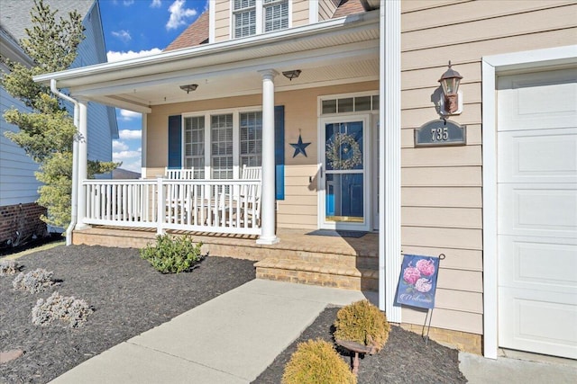 property entrance featuring a porch, roof with shingles, and a garage