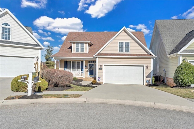 traditional home featuring roof with shingles, covered porch, concrete driveway, central AC, and a garage