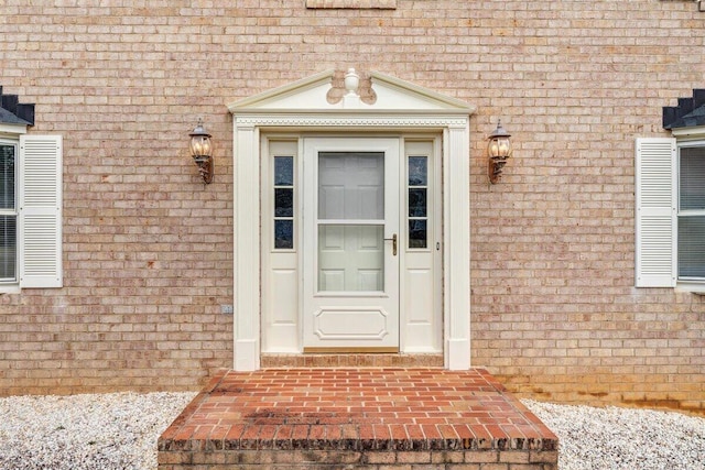 view of exterior entry with brick siding