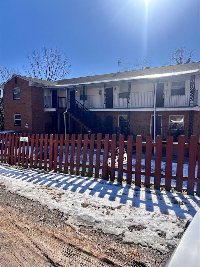 view of front of home with a fenced front yard and brick siding