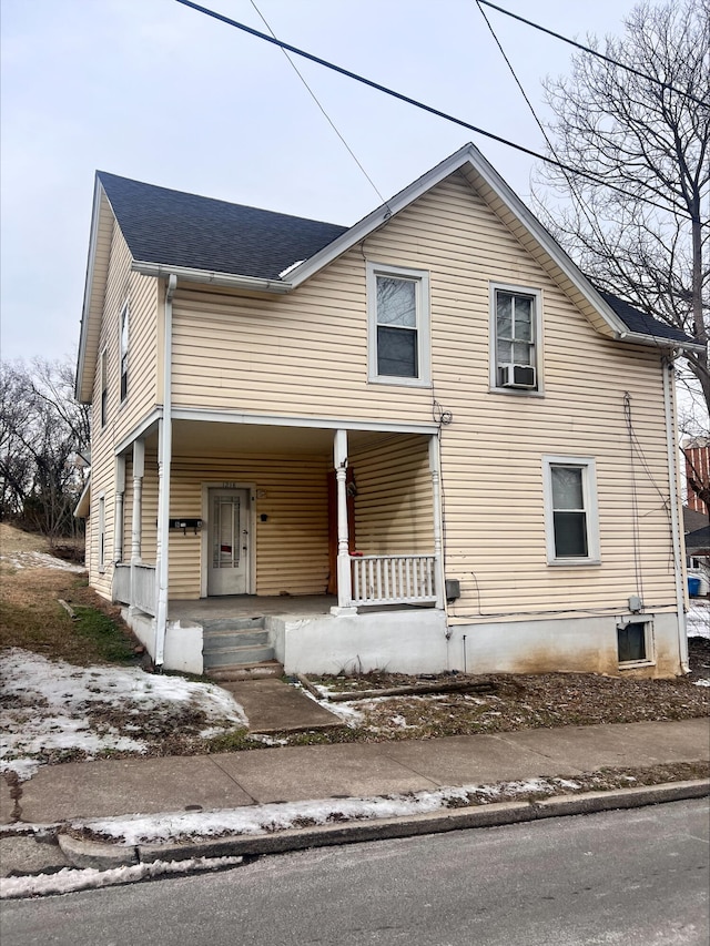 view of front of property with a porch, cooling unit, and roof with shingles