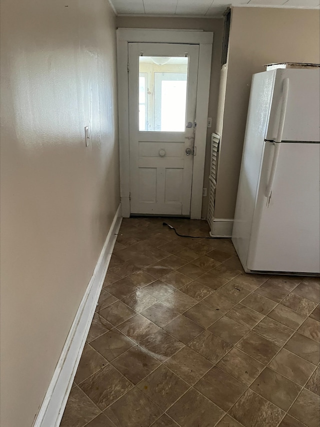 doorway to outside featuring baseboards