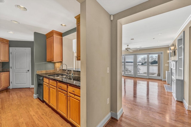 kitchen with a sink, light wood-type flooring, brown cabinetry, and dishwasher