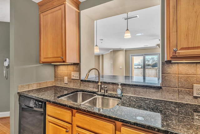 kitchen with dark stone counters, black dishwasher, decorative light fixtures, and a sink