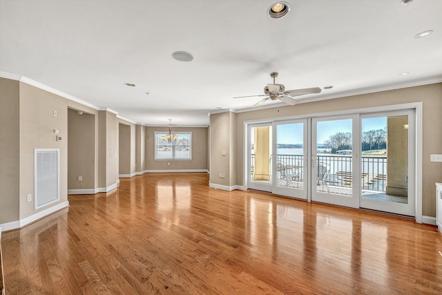 unfurnished living room with light wood-style floors, a water view, ornamental molding, and visible vents