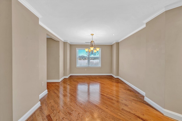 spare room with baseboards, a chandelier, wood finished floors, and ornamental molding