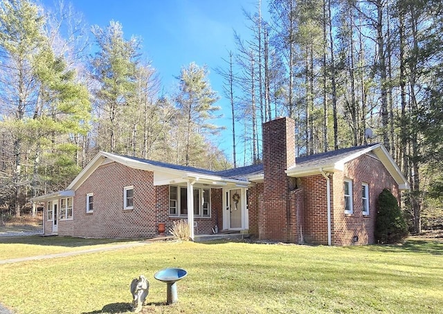 ranch-style home with a porch, a front yard, brick siding, and a chimney