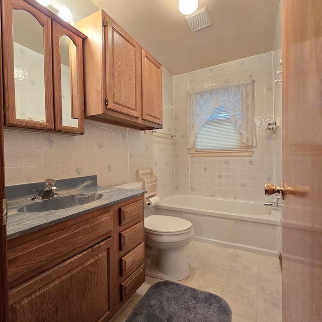 bathroom with visible vents, toilet, tile patterned floors, vanity, and tile walls