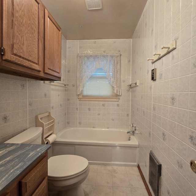 bathroom featuring toilet, tile patterned flooring, visible vents, and tile walls