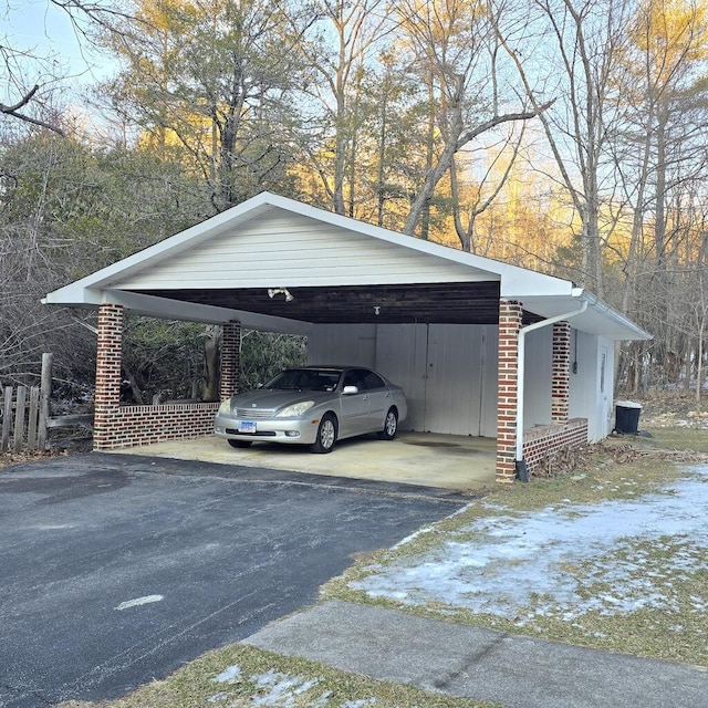 view of vehicle parking featuring aphalt driveway and a detached carport