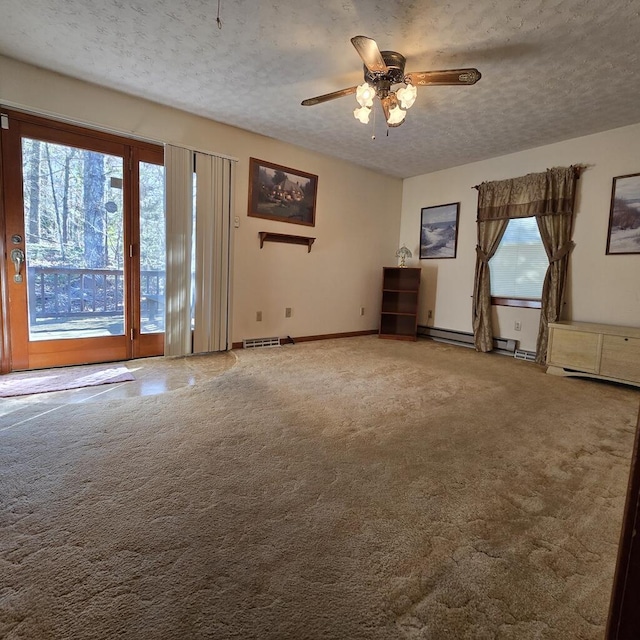 carpeted spare room featuring a ceiling fan, baseboards, visible vents, and a textured ceiling