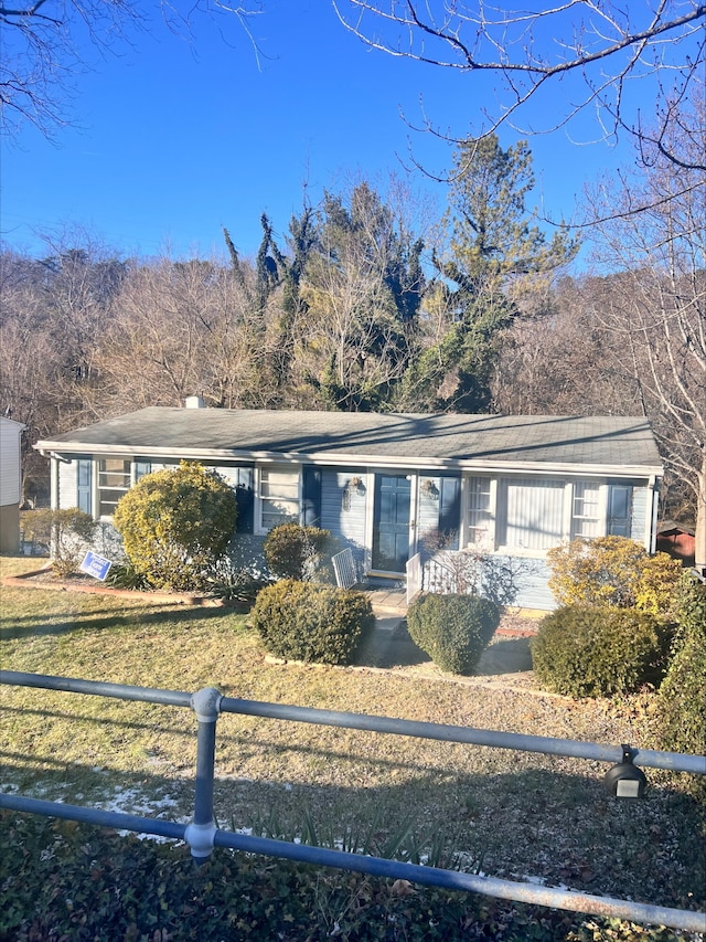 ranch-style house featuring a front yard and fence private yard