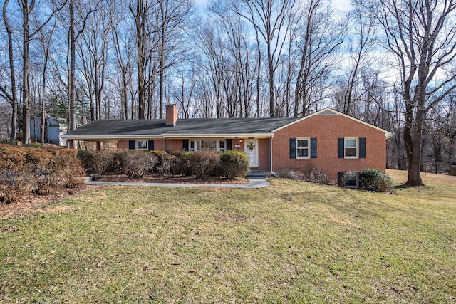 ranch-style home featuring brick siding, a chimney, and a front lawn