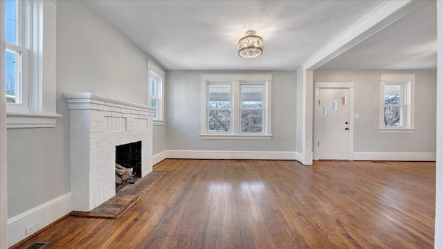 unfurnished living room with a fireplace, wood finished floors, and baseboards