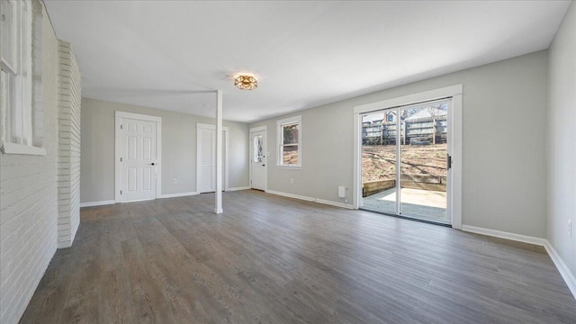 interior space featuring access to outside, dark wood finished floors, and baseboards