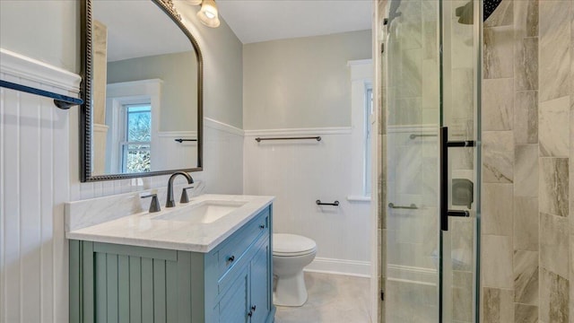 bathroom with a stall shower, vanity, and toilet