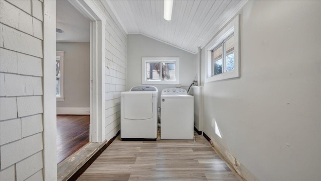 laundry area with laundry area, baseboards, washer and clothes dryer, ornamental molding, and light wood-type flooring