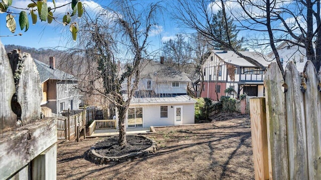 back of house with a residential view, metal roof, fence, and a standing seam roof