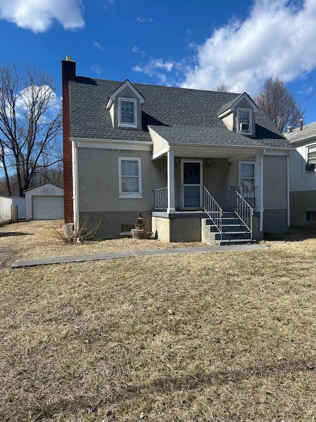 view of front of home featuring an outbuilding, a porch, a shingled roof, stucco siding, and a front lawn