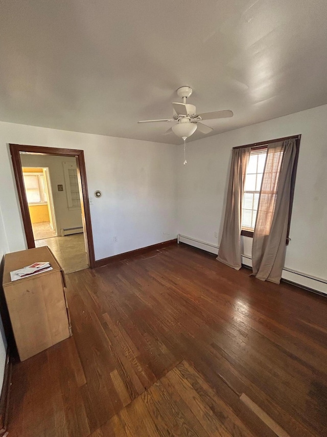 unfurnished room featuring dark wood finished floors, baseboard heating, a baseboard heating unit, ceiling fan, and baseboards