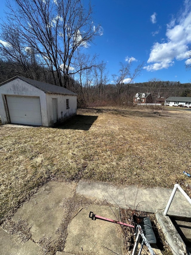 view of yard with a garage and an outbuilding