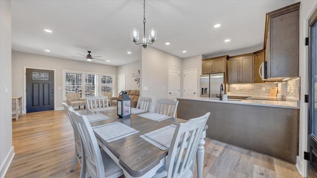 dining area featuring light wood-style floors, ceiling fan with notable chandelier, and recessed lighting