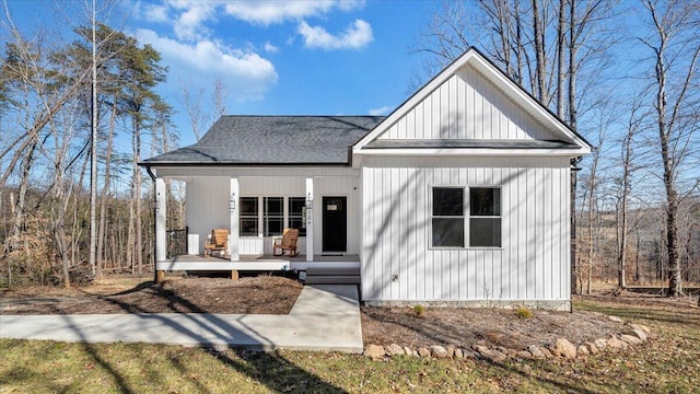 modern farmhouse style home with covered porch and roof with shingles