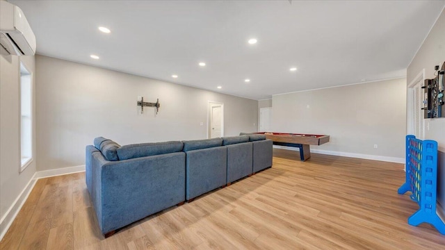 living room with recessed lighting, baseboards, a wall mounted air conditioner, and light wood finished floors