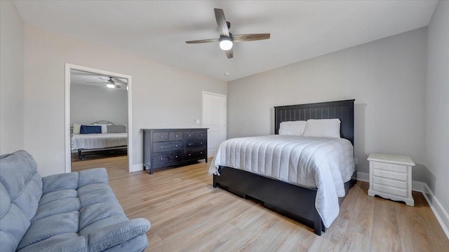 bedroom featuring light wood finished floors, baseboards, and a ceiling fan