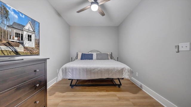 bedroom with baseboards, ceiling fan, and light wood-style floors