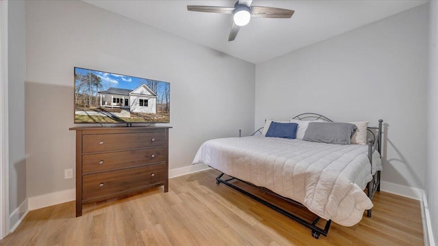 bedroom featuring lofted ceiling, light wood-style flooring, baseboards, and a ceiling fan