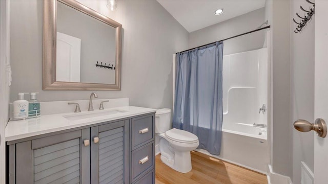 full bathroom featuring toilet, shower / bath combo, wood finished floors, and vanity