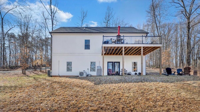 rear view of house featuring a lawn, a wooden deck, and central air condition unit