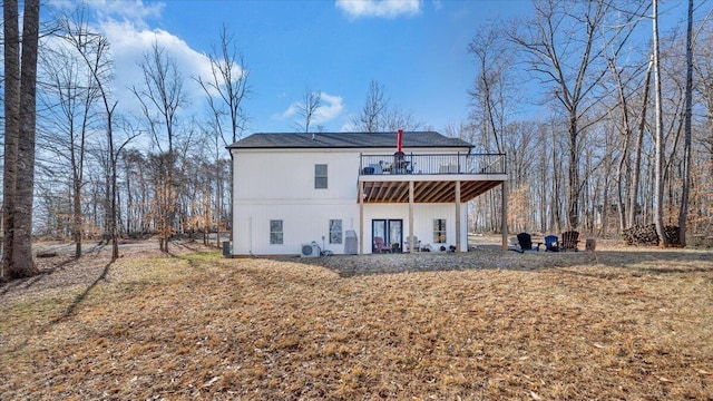 back of house featuring a deck and a yard