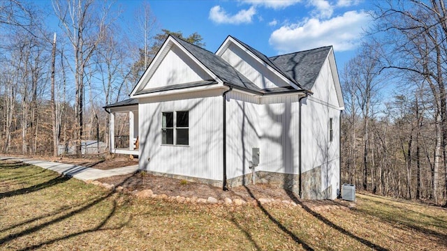 view of home's exterior with roof with shingles, a lawn, and central air condition unit