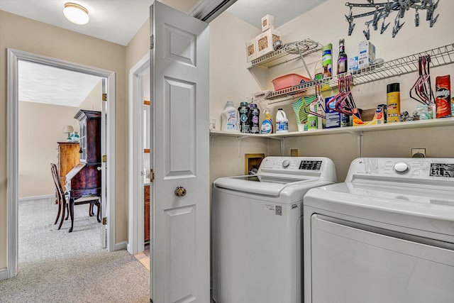 laundry area with washing machine and dryer, laundry area, light carpet, and baseboards