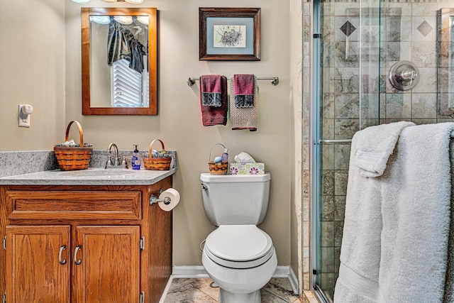 full bathroom featuring vanity, a shower stall, toilet, and baseboards