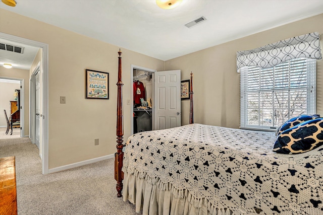 bedroom featuring carpet floors, a walk in closet, visible vents, and baseboards