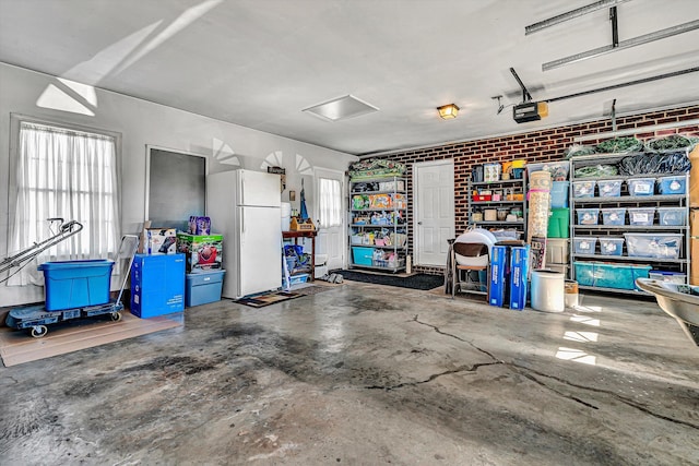 garage featuring a garage door opener and freestanding refrigerator