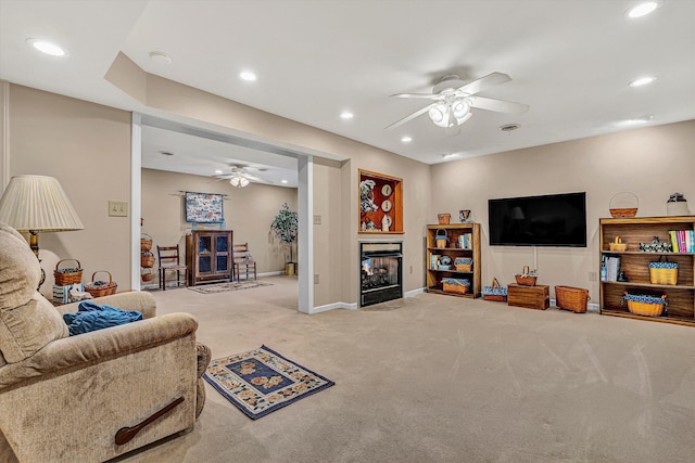 carpeted living area with baseboards, a multi sided fireplace, a ceiling fan, and recessed lighting