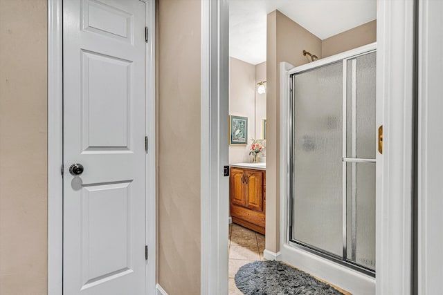 bathroom with a stall shower, vanity, and tile patterned floors