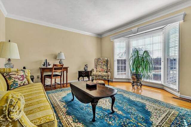 living room with wood finished floors, visible vents, and crown molding