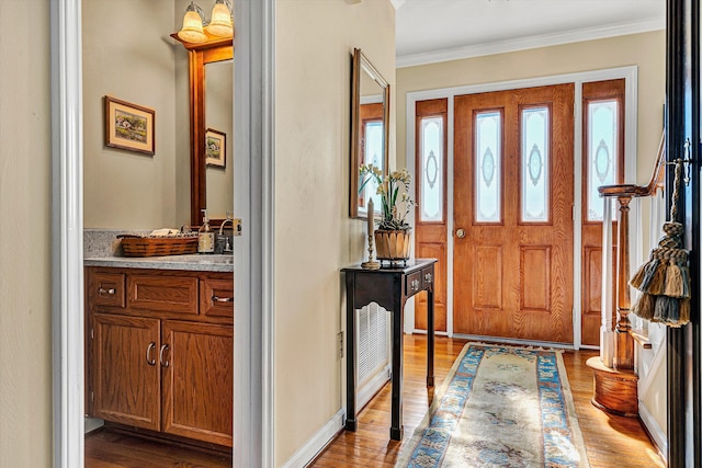 foyer entrance featuring ornamental molding and wood finished floors