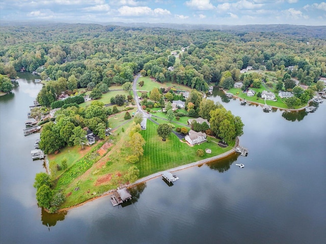 birds eye view of property featuring a water view and a wooded view