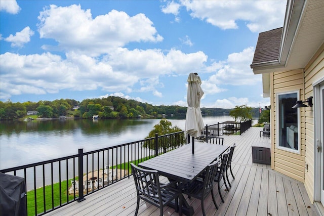 wooden deck featuring a water view, outdoor dining space, and area for grilling