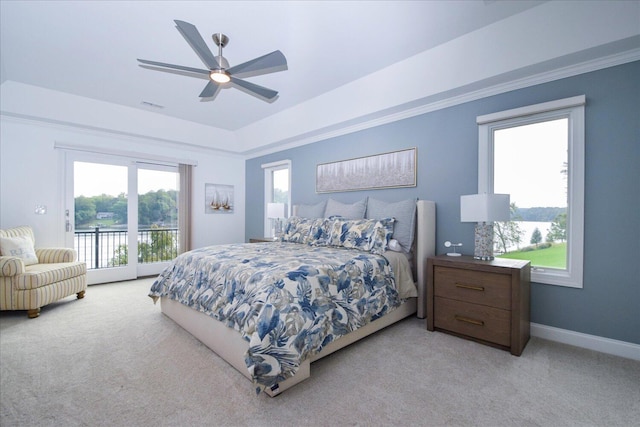 bedroom with light carpet, access to outside, baseboards, and a tray ceiling